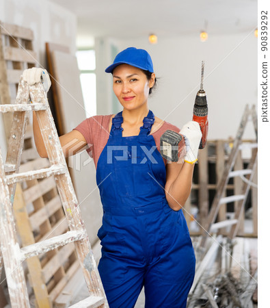 Portrait of smiling asian woman repairer with drill 90839292
