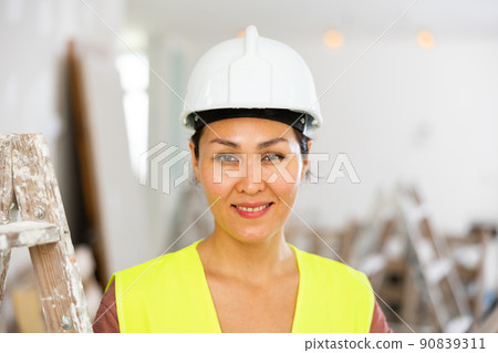 Portrait of positive woman builder during repair works 90839311