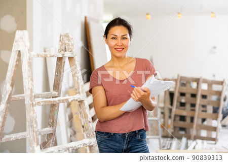 Positive woman designer with documents in construction site 90839313