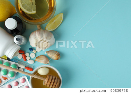 Concept of treatment colds with honey and garlic on blue background Concept of treatment colds with honey and garlic on blue background 90839758
