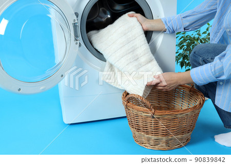Concept of housework with washing machine and girl on blue background Concept of housework with washing machine and girl on blue background 90839842
