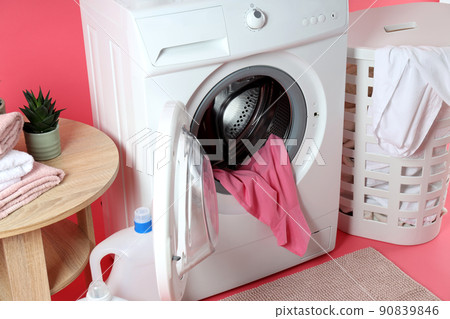 Concept of housework with washing machine on pink background Concept of housework with washing machine on pink background 90839846
