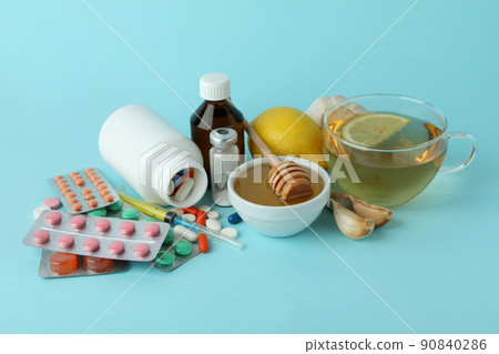 Concept of treatment colds with honey and garlic on blue background Concept of treatment colds with honey and garlic on blue background 90840286