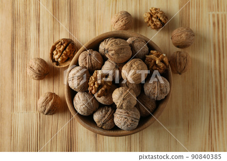 Walnuts in wooden bowl on wooden background 90840385