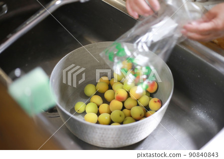 Woman washing plums 90840843