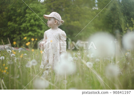 Beautiful child with dandelion flowers in park in summer. Happy kid having fun outdoors. 90841197