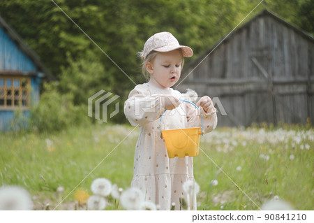 Beautiful child with dandelion flowers in park in summer. Happy kid having fun outdoors. 90841210