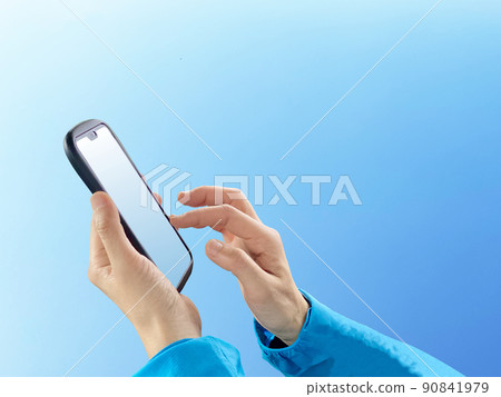 Hand tapping smartphone_blue sky background Hand tapping smartphone_blue sky background 90841979
