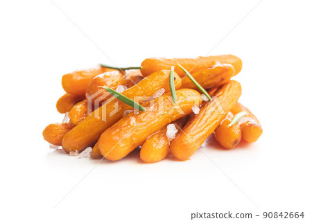 Roasted baby carrots with salt and rosemary isolated on white background. Roasted baby carrots with salt and rosemary isolated on white background. 90842664
