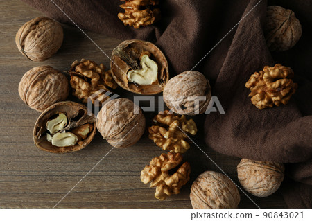 Walnuts with kitchen towel on wooden background Walnuts with kitchen towel on wooden background 90843021