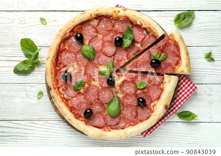 Concept of tasty food with Salami pizza on white wooden background Concept of tasty food with Salami pizza on white wooden background 90843039