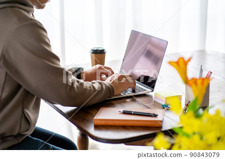 At the hands of a middle-aged businessman who teleworks at home At the hands of a middle-aged businessman who teleworks at home 90843079
