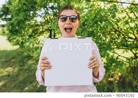 Happy Woman in sunglasses holding a box with pizza on nature background. Fast pizza delivery. Mock up. Fast food banner, summer time 90843192