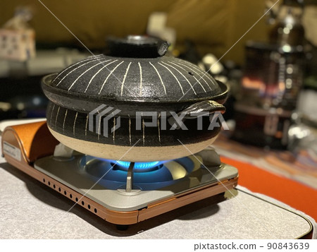 Hot pot cooking on a cassette stove in the tent 90843639