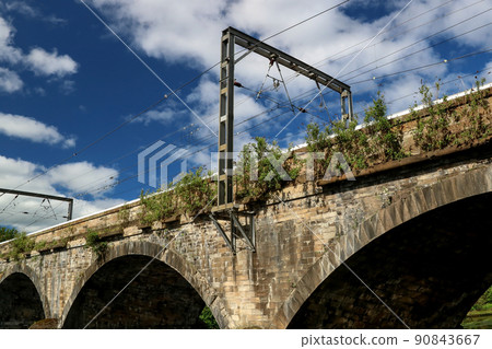 Railway Bridge Over a River Against a Cloudy Blue Morning Sky Railway Bridge Over a River Against a Cloudy Blue Morning Sky 90843667