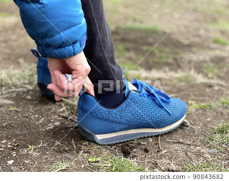 The action of putting a finger in the heel of athletic shoes The action of putting a finger in the heel of athletic shoes 90843682