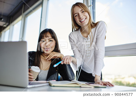 Happy Asian and Caucasian with education textbook and digital laptop computer posing 90844577