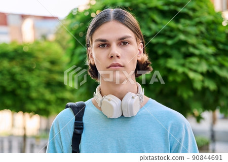 Serious teenage male student looking at camera outdoor Serious teenage male student looking at camera outdoor 90844691