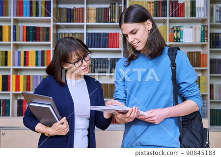 Talking female teacher and guy college student, in the library room 90845183