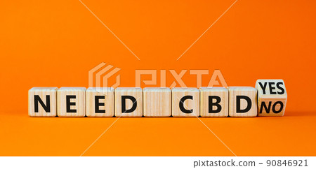 Need CBD, cannabidiol symbol. Turned a wooden cube and changed words 'need CBD no' to 'need CBD yes'. Beautiful orange background, copy space. Medical and need CBD cannabidiol concept. 90846921