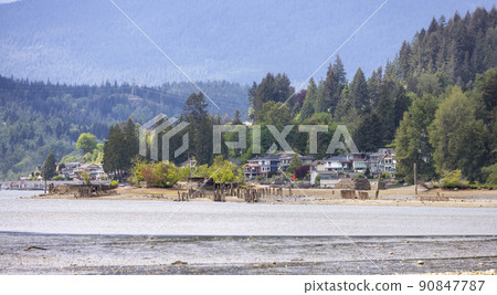 Residential Homes by the water and mountains in background. 90847787