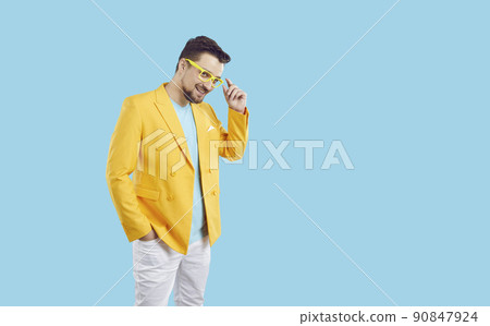 Portrait of cheerful cool and stylish millennial man in colorful outfit on light blue background. Portrait of cheerful cool and stylish millennial man in colorful outfit on light blue background. 90847924