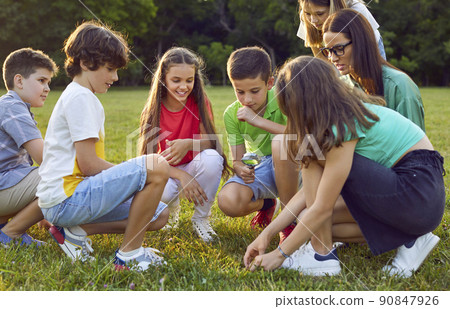 School children learning about nature and looking at plants through magnifying glass 90847926