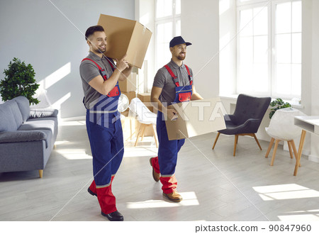 Two workers from moving and delivery service removing cardboard boxes from the house Two workers from moving and delivery service removing cardboard boxes from the house 90847960
