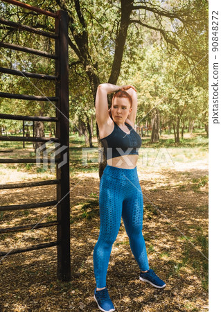 young athletic woman stretching to warm up her body before exercise. athlete practising sport outdoors. health and wellness lifestyle. young athletic woman stretching to warm up her body before exercise. athlete practising sport outdoors. health and wellness lifestyle. 90848272