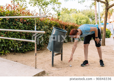 young urban girl, picking up rubbish from the ground to deposit it in a litter bin. young woman environmentalist in city. young urban girl, picking up rubbish from the ground to deposit it in a litter bin. young woman environmentalist in city. 90848336
