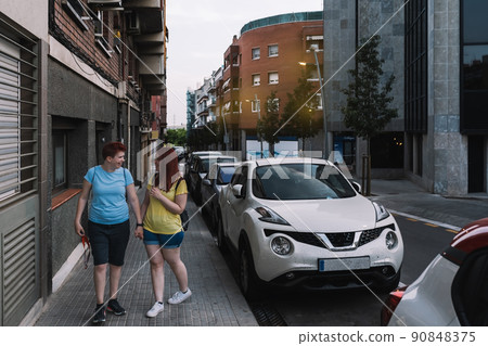 two young sisters chatting happily as they walk home through the streets of the big city. young girls in the city sharing free time while gossiping. concept of friendship and companionship. two young sisters chatting happily as they walk home through the streets of the big city. young girls in the city sharing free time while gossiping. concept of friendship and companionship. 90848375
