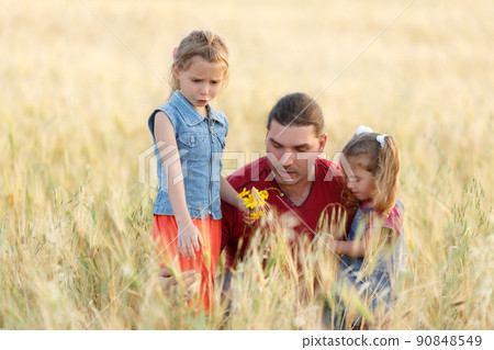 Happy father and little daughters spending time. Father and daughters playing . Dad holding on hands his two sisters children. 90848549