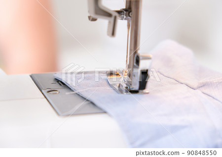 A man sews clothes on sewing machine. Hobbies A man sews clothes on sewing machine. Hobbies 90848550