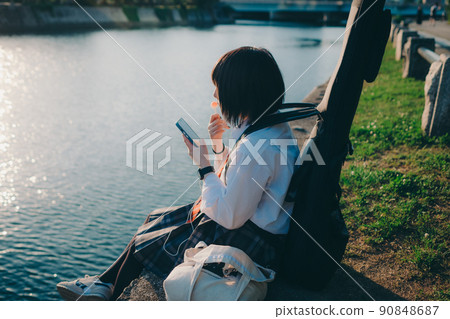 Schoolgirl in uniform with a guitar and smartphone and the city Schoolgirl in uniform with a guitar and smartphone and the city 90848687