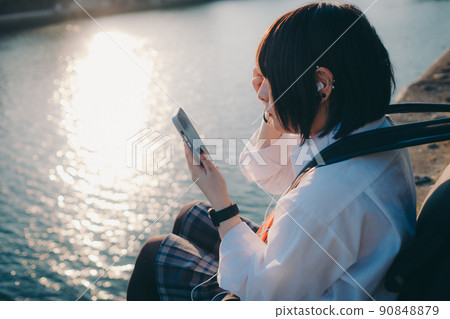 穿著制服的女學生有吉他和智能手機和城市 穿著制服的女學生有吉他和智能手機和城市 90848879