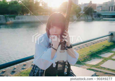 Schoolgirl in uniform with a guitar and the city Schoolgirl in uniform with a guitar and the city 90849277