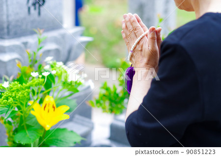 A woman holding her hand to the grave 90851223