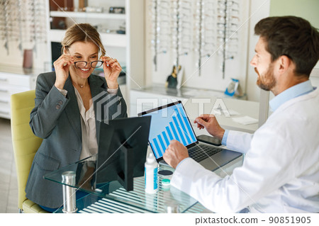 The ophthalmologist helps the client to choose a more suitable spectacle frame 90851905