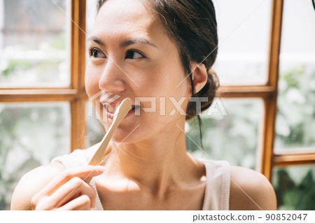 Women who brush their teeth and women who use bamboo toothbrushes Women who brush their teeth and women who use bamboo toothbrushes 90852047