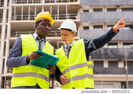 Two architect, civil engineer or building contractor colleagues on construction site 90852051