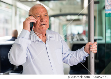 Old man talking on phone in streetcar Old man talking on phone in streetcar 90852340