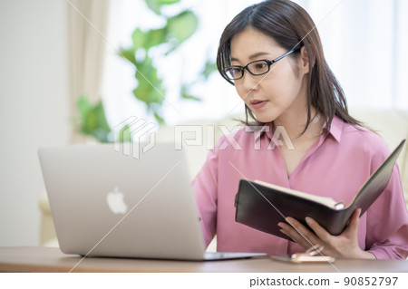 A woman in her thirties working from home in the living room 90852797
