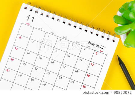 November 2022 desk calendar on yellow background. 90853072