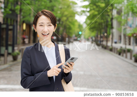 操作智能手機的婦女戶外 90853658