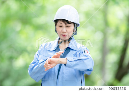 Women in work clothes, fresh green helmet, stretch Women in work clothes, fresh green helmet, stretch 90853838