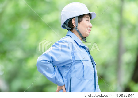 Women in work clothes, fresh green helmet, stretch Women in work clothes, fresh green helmet, stretch 90853844