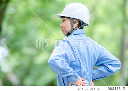 Women in work clothes, fresh green helmet, stretch Women in work clothes, fresh green helmet, stretch 90853845
