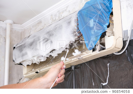 man sprays special foam to clean air conditioners man sprays special foam to clean air conditioners 90854058