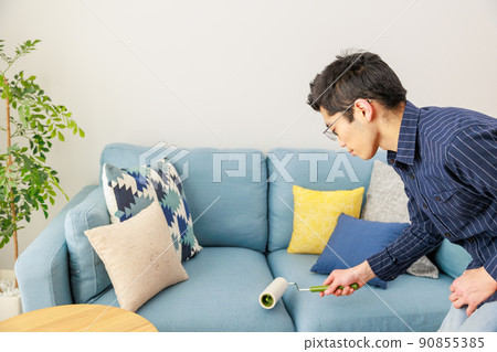 A man cleaning with an adhesive carpet cleaner 90855385