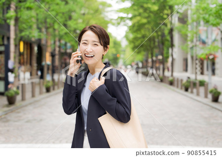 Women in their 30s and 40s making phone calls Women in their 30s and 40s making phone calls 90855415